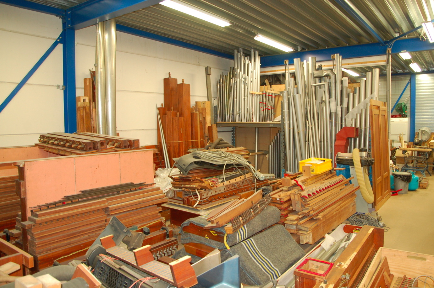 Verdiepingsvloer bedrijfshal met opslag orgelonderdelen op pallets